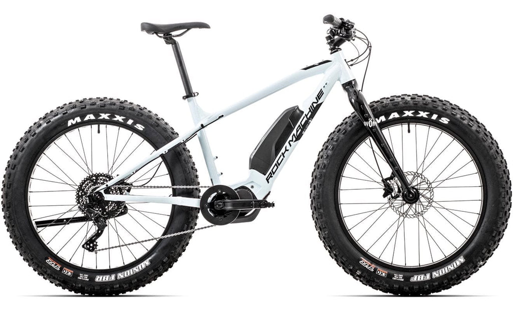 SÄHKÖPYÖRÄT.NETin Rock Machine Pyry E50R on valkoinen sähköpyörä, jossa on Maxxis-renkaat, Shimano EP6 -moottori, runkoon asennettu akku ja etujousitushaarukka, joka näkyy sivulta valkoisella taustalla.